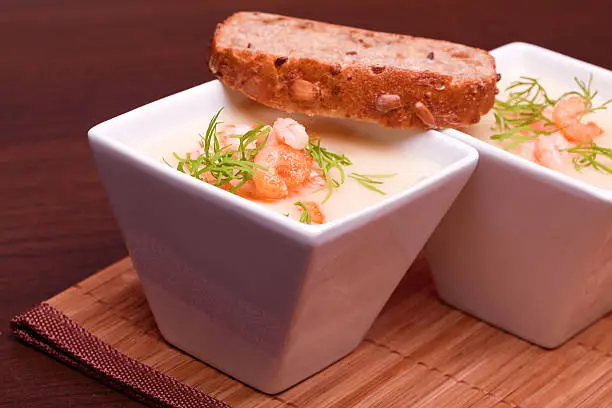 Una sopa de pescado acompañada con pan integral